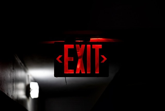 Illuminated emergency exit sign in modern commercial facility